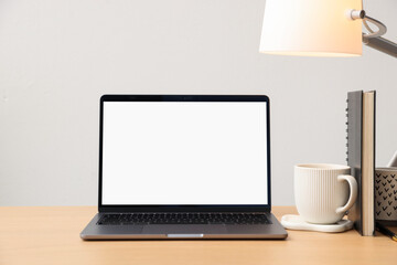 Fototapeta premium Stylish workplace with laptop, stationery, cup and decor indoors