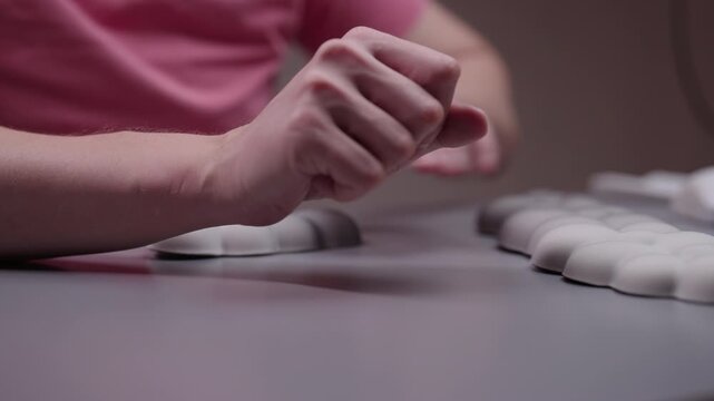 Office worker stretching hands and wrists while using ergonomic support rest for mouse and keyboard, showing thumbs up gesture for comfort and pain relief sitting at desk, close-up, slow motion.