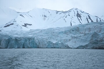 Majestic arctic glacier surrounded by snow covered mountains © rene_dra