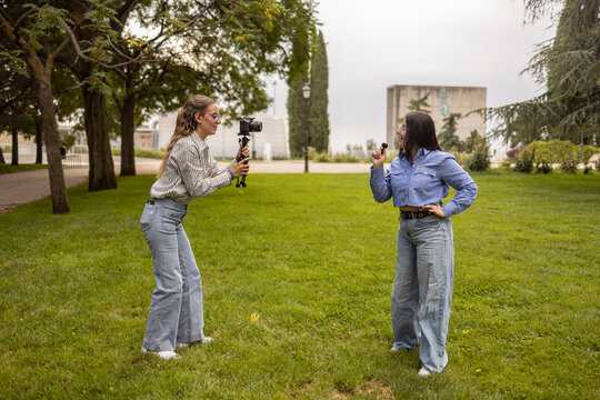 Female students filming a campus vlog on the lawn