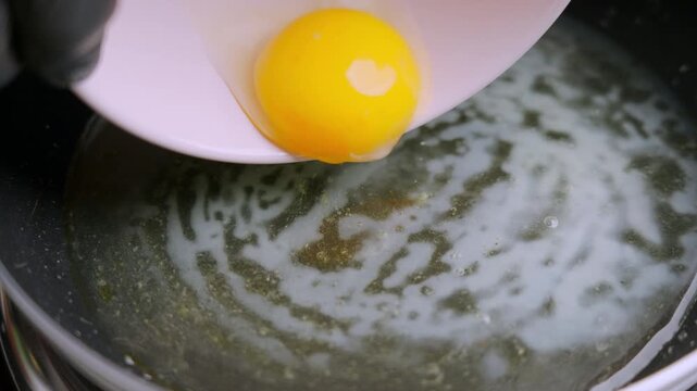Frying the Perfect Egg. Vivid snapshot of eggs cooking in shimmering hot skillet. Detailed view of egg yolk spreading over hot oil in rustic