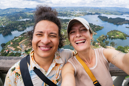 Multiethnic couple selfie over Guatape lakes, Antioquia