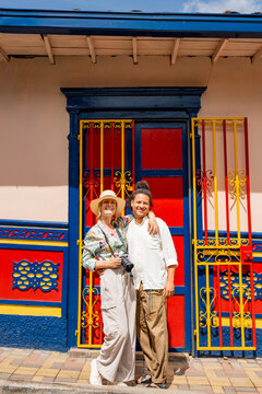 Multiethnic couple posing by colorful door in Guatape