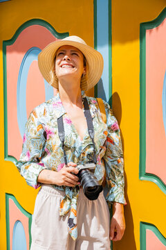Smiling tourist photographer in colorful Guatape street