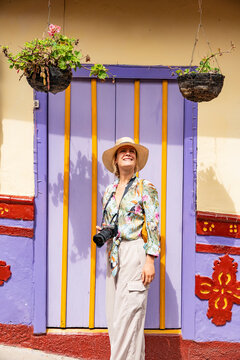 Traveler with camera by colorful door in Guatape, Colombia