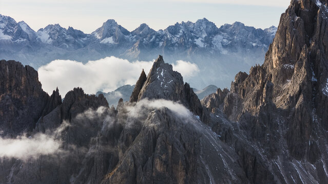 Aerial view of the jagged peaks of the Cadini group with swirling clouds and mist in the heart of the Dolomites Auronzo di Cadore, Veneto, Italy.