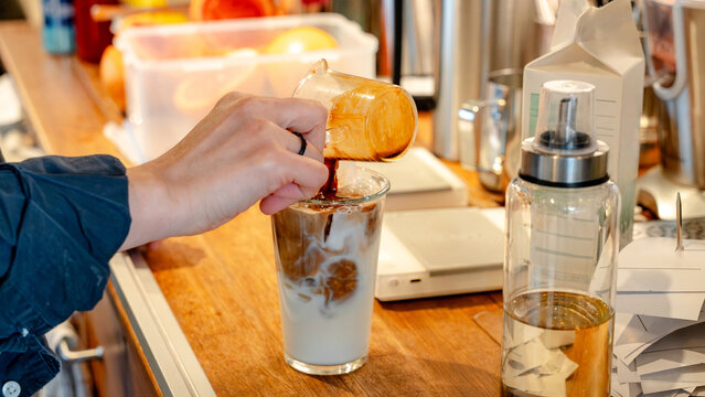 Barista crafting iced coffee in Korean cafe