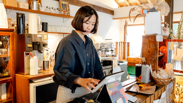 Cozy coffee shop cashier interacting with touchscreen