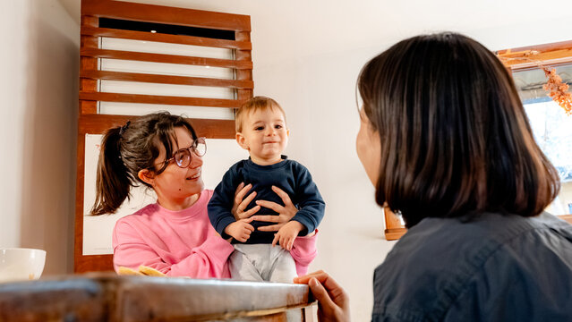 Mother enjoying coffee time with barista in cozy shop