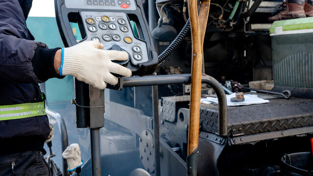 Worker operating heavy machinery for road repair
