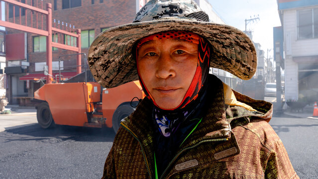 Worker in city street paving and repair operation