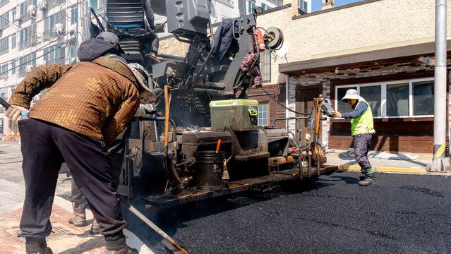 Workers paving asphalt road in Gyeongju, South Korea