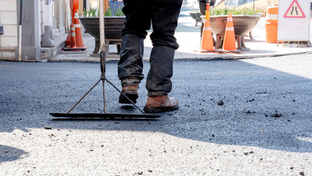 Workers paving asphalt on urban city street