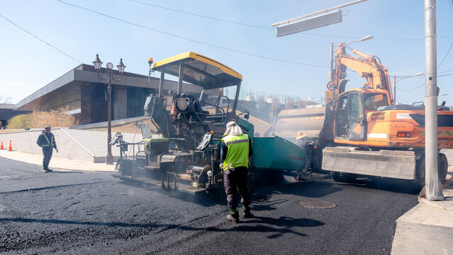 Workers paving street with machinery in Gyeongju