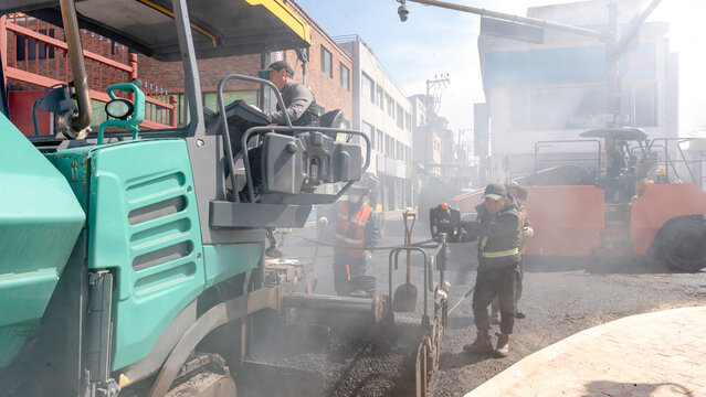Workers and machinery on street paving project