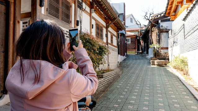 Traditional houses in Bukchon with tourist capturing moment