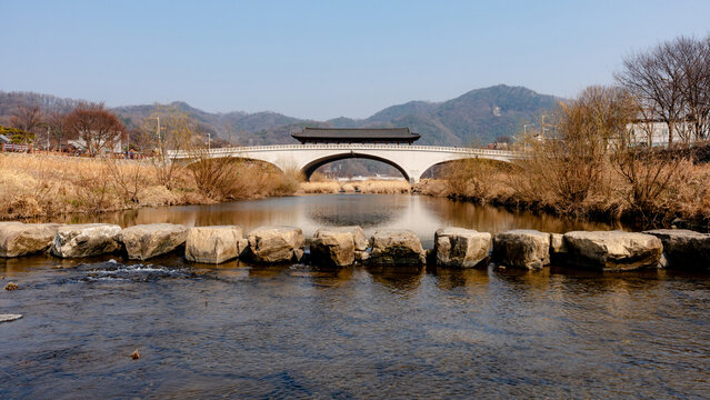 Namcheongyo Bridge over calm river with mountain backdrop