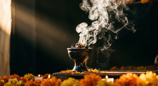 Burning Copal Incense with Rising Smoke Surrounded by Marigold Flowers and Candles During Traditional D&iacute;a de los Muertos Ritual in Mexico