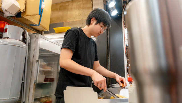 Taiwanese night market vendor preparing street food at stall