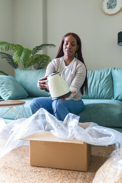 Black woman reviewing used appliance from secondhand app