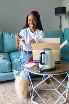 Black woman packing used appliance order for resale app