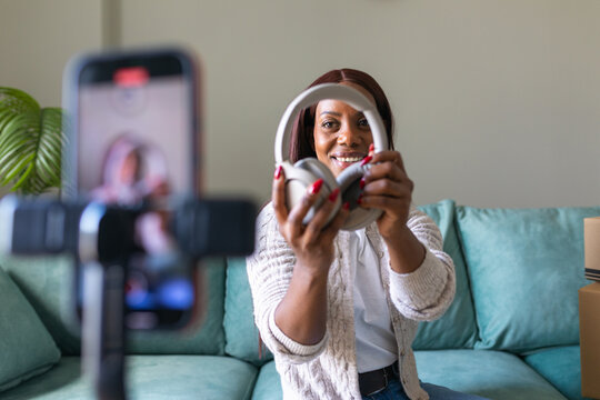 Black woman selling secondhand headphones in online video