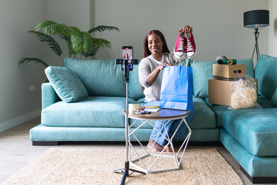 Black woman listing sneakers on secondhand shopping app