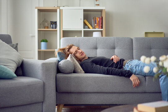 Young man lying on sofa during therapy session at home