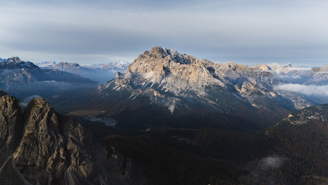 Aerial view of the Monte Cristallo rugged peaks and rock formations above misty valleys in the Dolomites, Tre Cime di Lavaredo, Veneto, Italy.