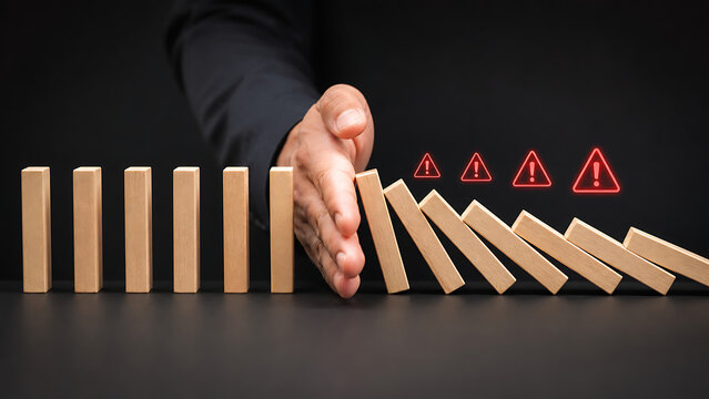 Businessman preventing domino effect collapse with wooden blocks symbolizing business protection crisis management financial stability leadership control and strategic risk reduction 