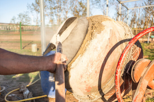 Concrete mixing in drum mixer at outdoor construction site