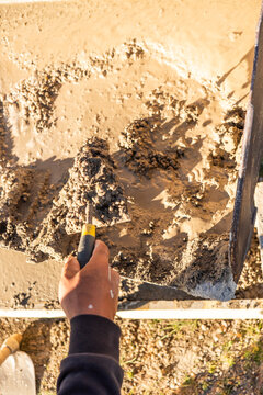 Construction worker finishing fresh concrete in exterior form