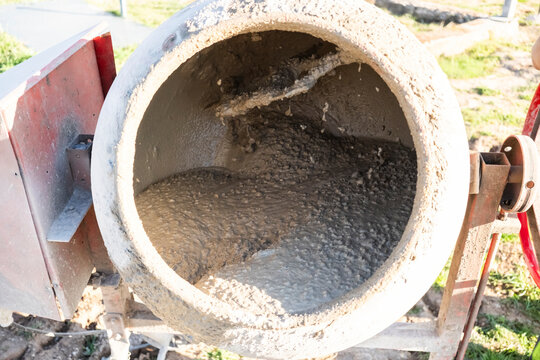 Wet concrete mixing in cement mixer at outdoor worksite
