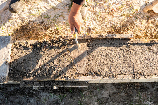 Construction worker finishing fresh concrete in exterior form