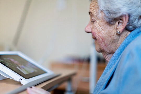 Elderly patient using tablet in hospital setting
