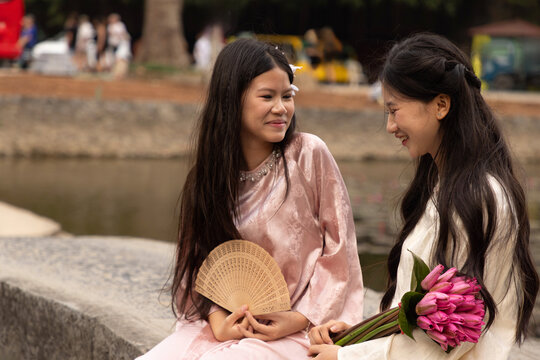 Young Vietnamese teenagers in ao dai by ancient temple