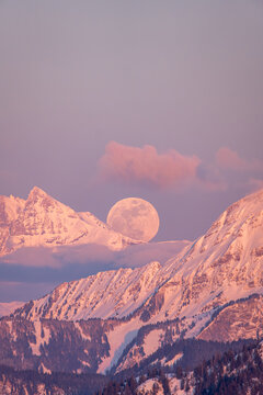 Moon rising over Dents du Midi during golden hour