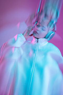 Futuristic woman in neon light with headphone and visor