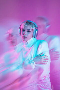 Futuristic woman in neon light with headphones and motion blur