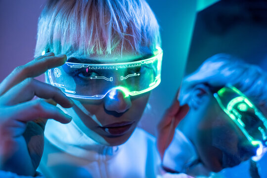 Futuristic woman using neon smart visor in cyberpunk lab