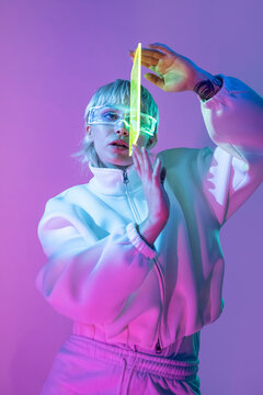 Futuristic woman in neon light with visor and crystal prism