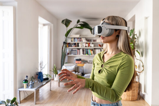 Woman using VR headset at home in bright living room