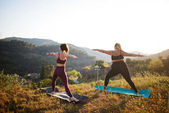 Outdoor yoga practice on hillside at sunrise in nature