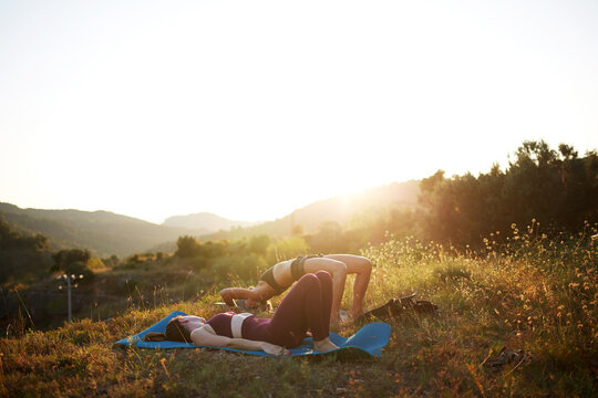 Outdoor yoga practice on hillside meadow at sunrise