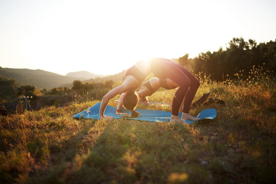 Sunset yoga backbend on mat in peaceful outdoor meadow