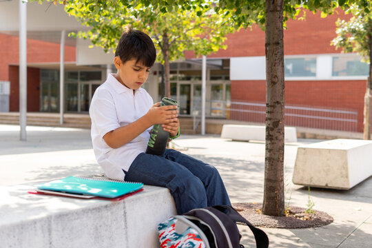 Boy exploring water bottle during school break
