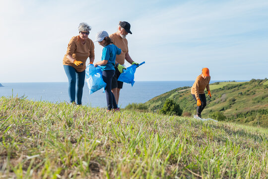 Family volunteers cleaning coastal hillside for sustainability