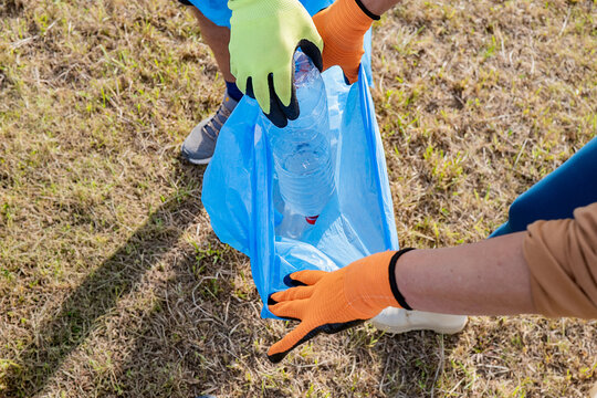 Volunteers collecting plastic bottles during outdoor cleanup