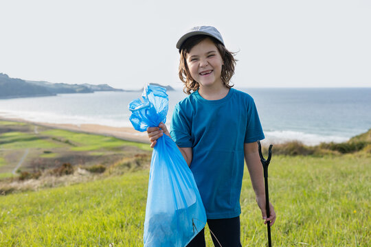 Young volunteer holding trash bag during coastal cleanup