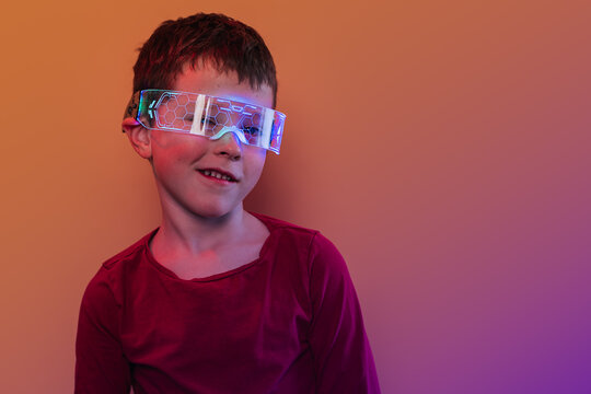 Kid wearing futuristic smart glasses glowing in neon light